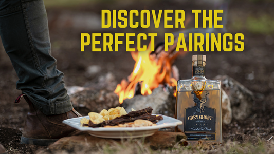 Person standing by a campfire with a bottle of premium Grey Ghost V.S.O.P Cape Brandy and a plate of snacks, inviting viewers to discover perfect pairings. 